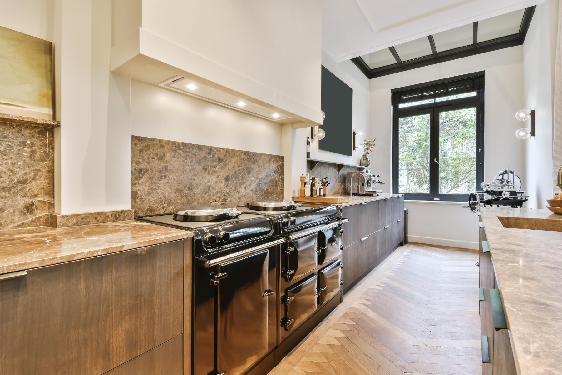A kitchen with quartzite counters, backsplash and SS stove