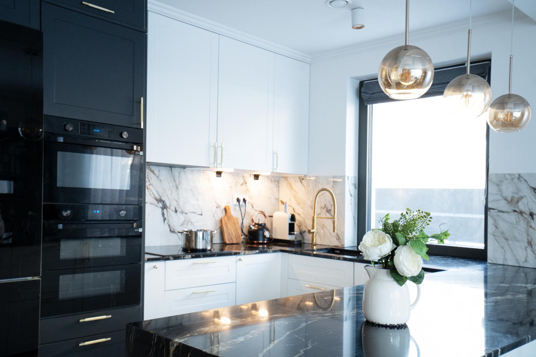 white and black modern kitchen with hanging fancy lights