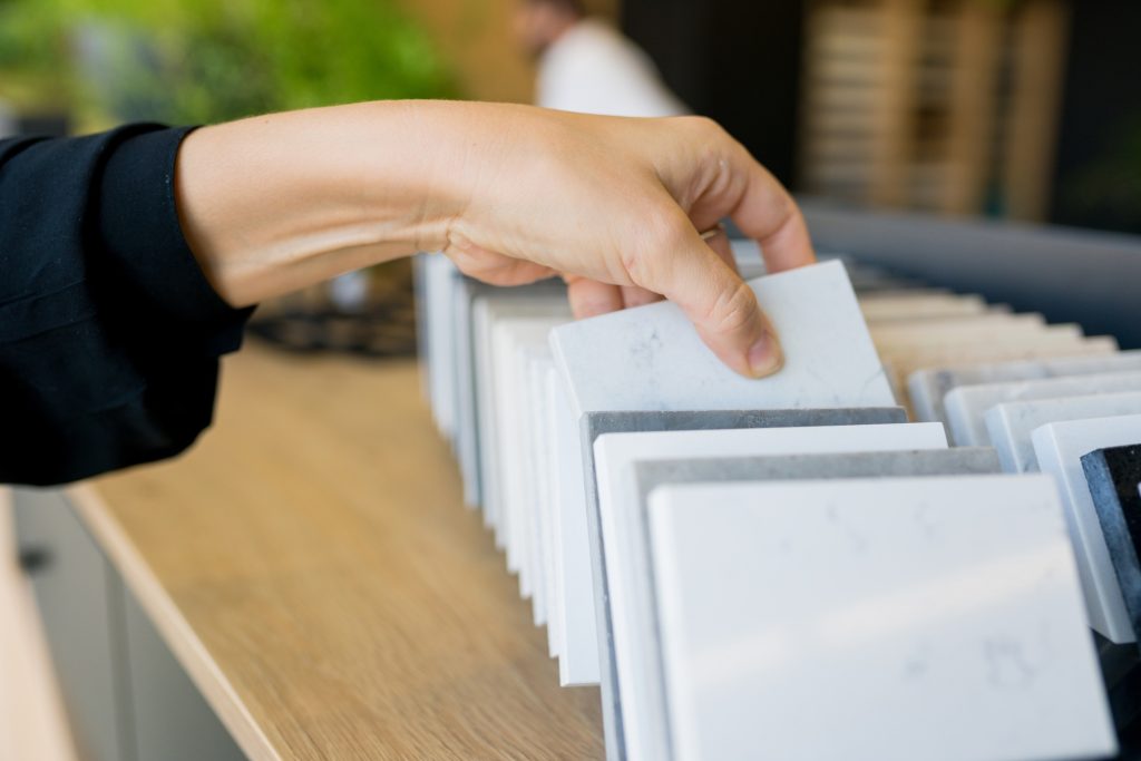 close up of woman choosing quartz materials for countertops in the kitchen
