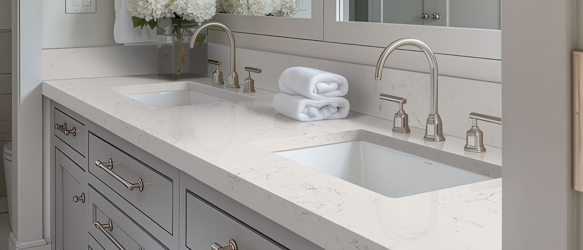 Carrara Marmi quartz countertop installed in a bright white bathroom with soft gray veining