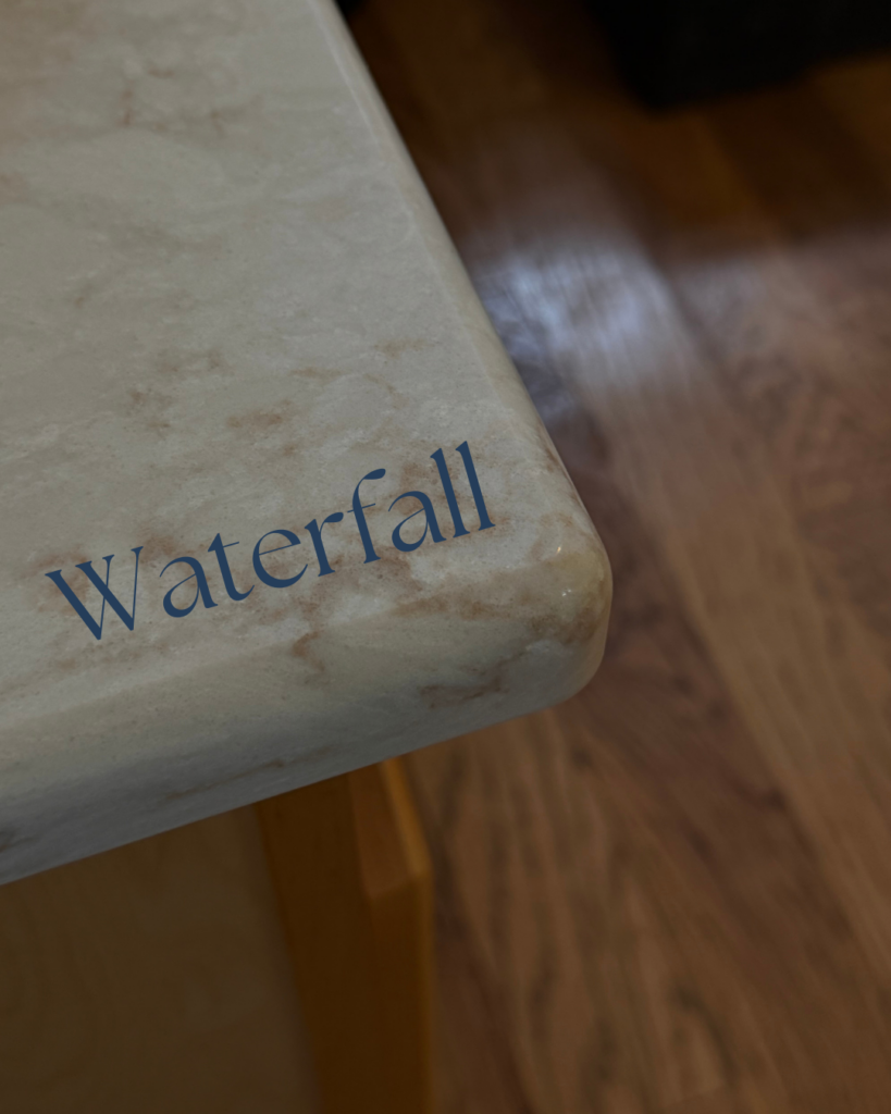 Waterfall countertop edge profile on island with stone extending vertically to the floor